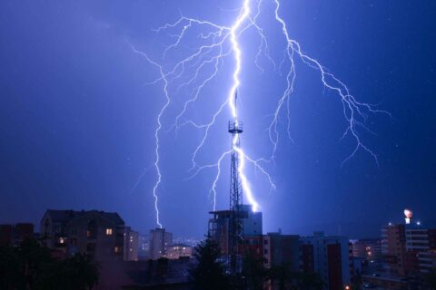 Lightning striking through rain droplets over rooftop in Dedham, MA