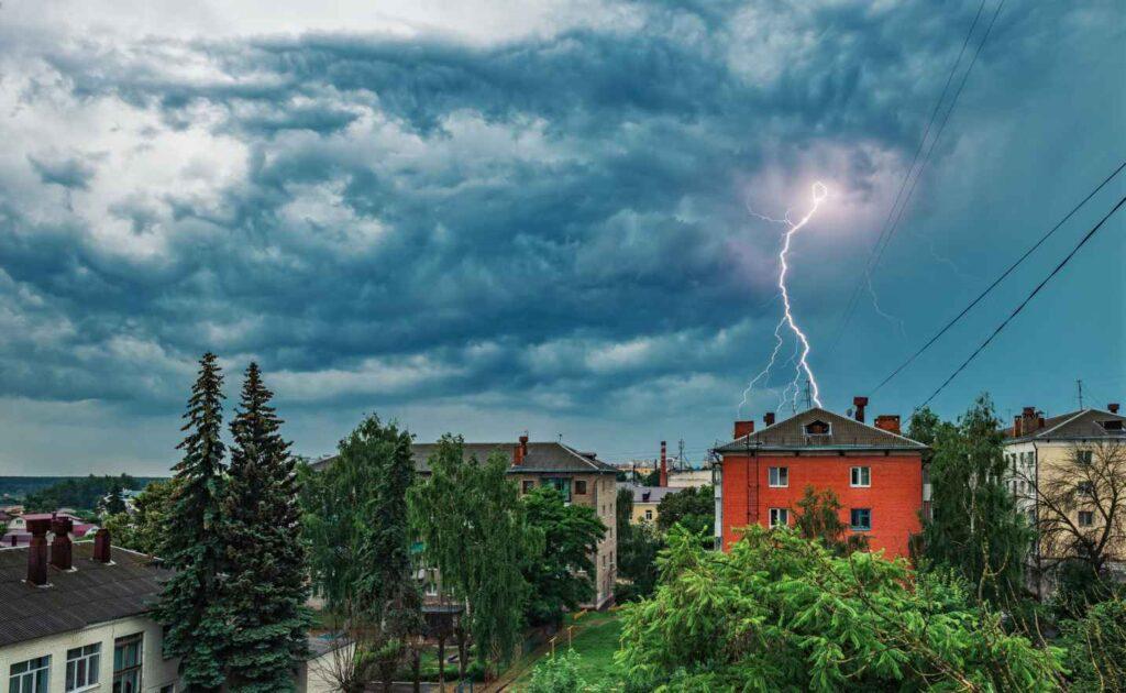 Powerful loop lightning arcs toward red building during storm in Dedham, MA
