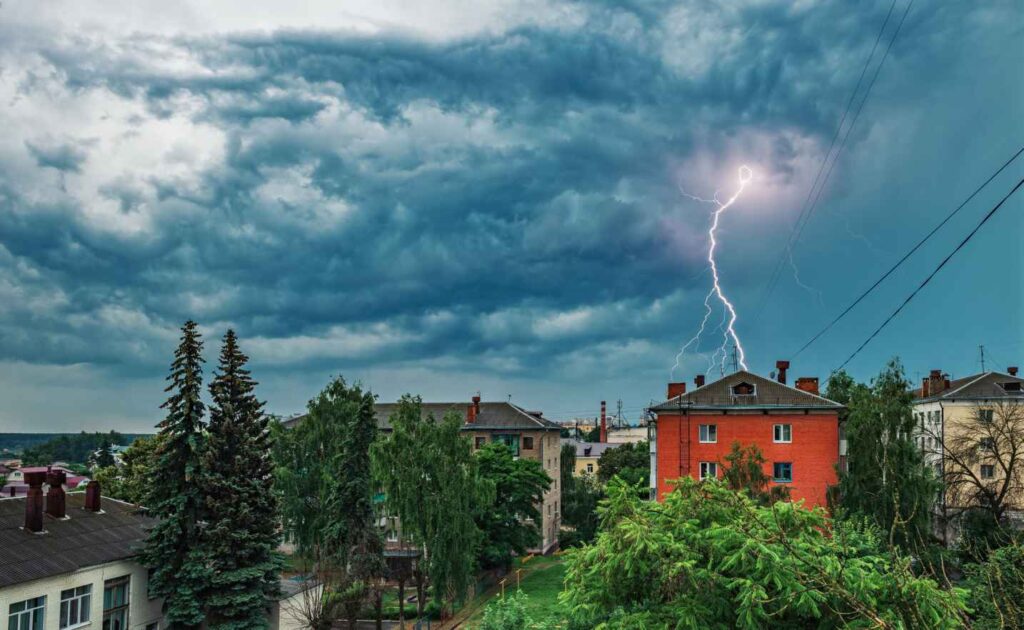 Powerful loop lightning arcs toward red building during storm in Dedham, MA