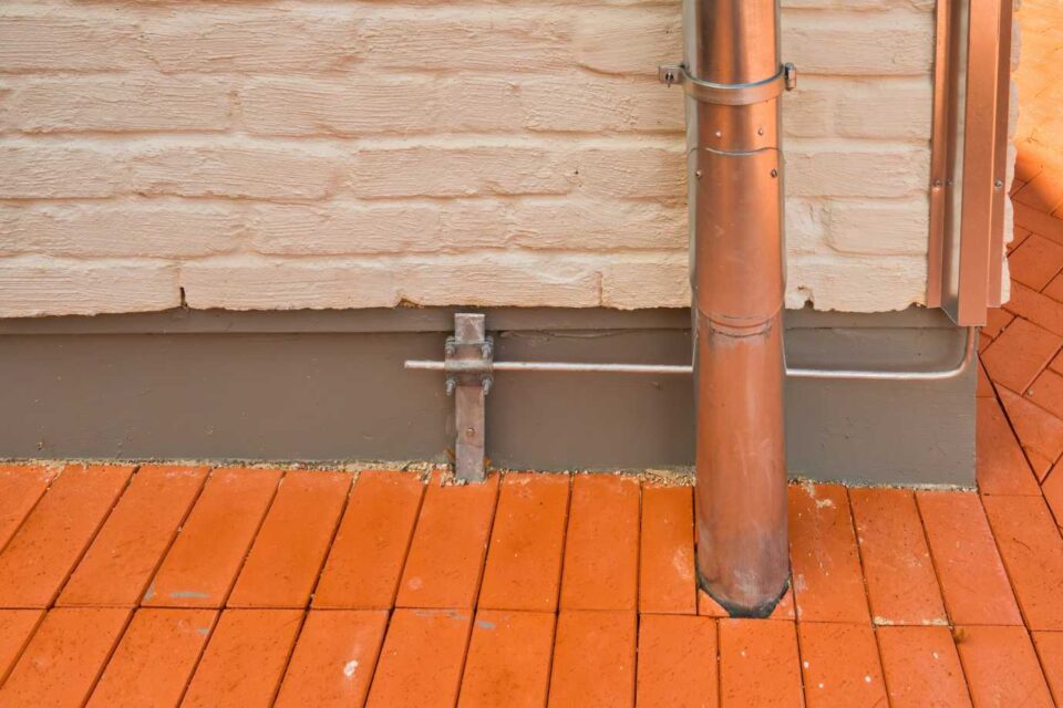 Install copper lightning rod grounding on brick wall in Dedham MA for surge protection