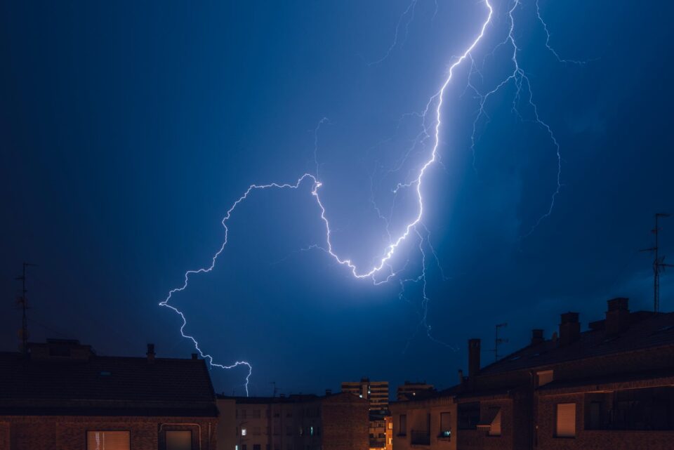Lightning strike over rooftops during storm in Dedham, MA