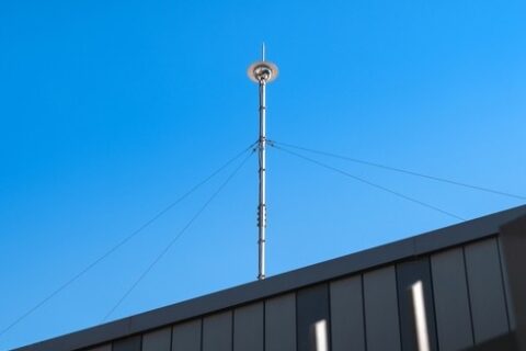 Metal fence with a tall pole, located at School Lightning Protection in Dedham, MA